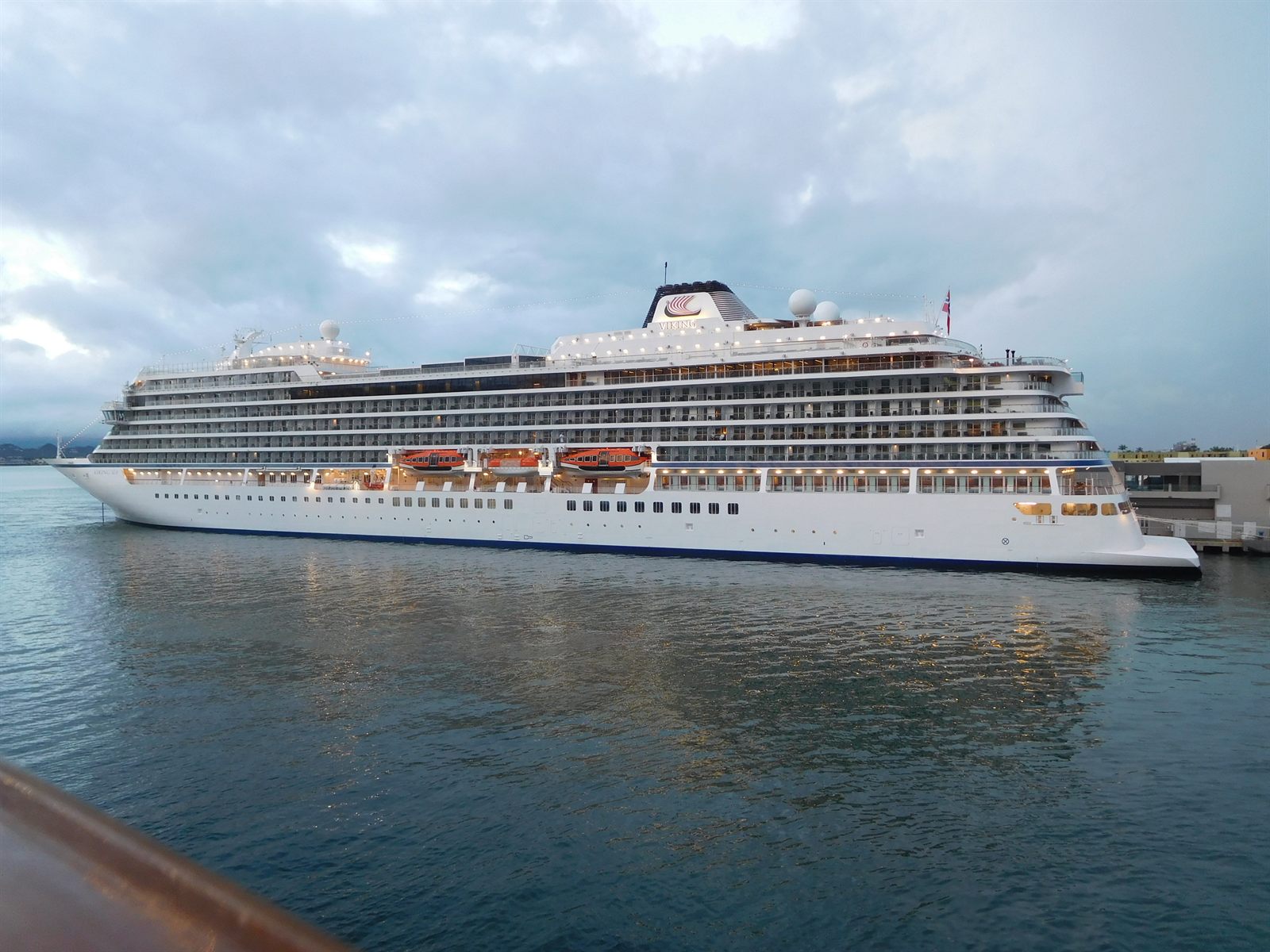 Mid-size white cruise ship at anchor in calm water