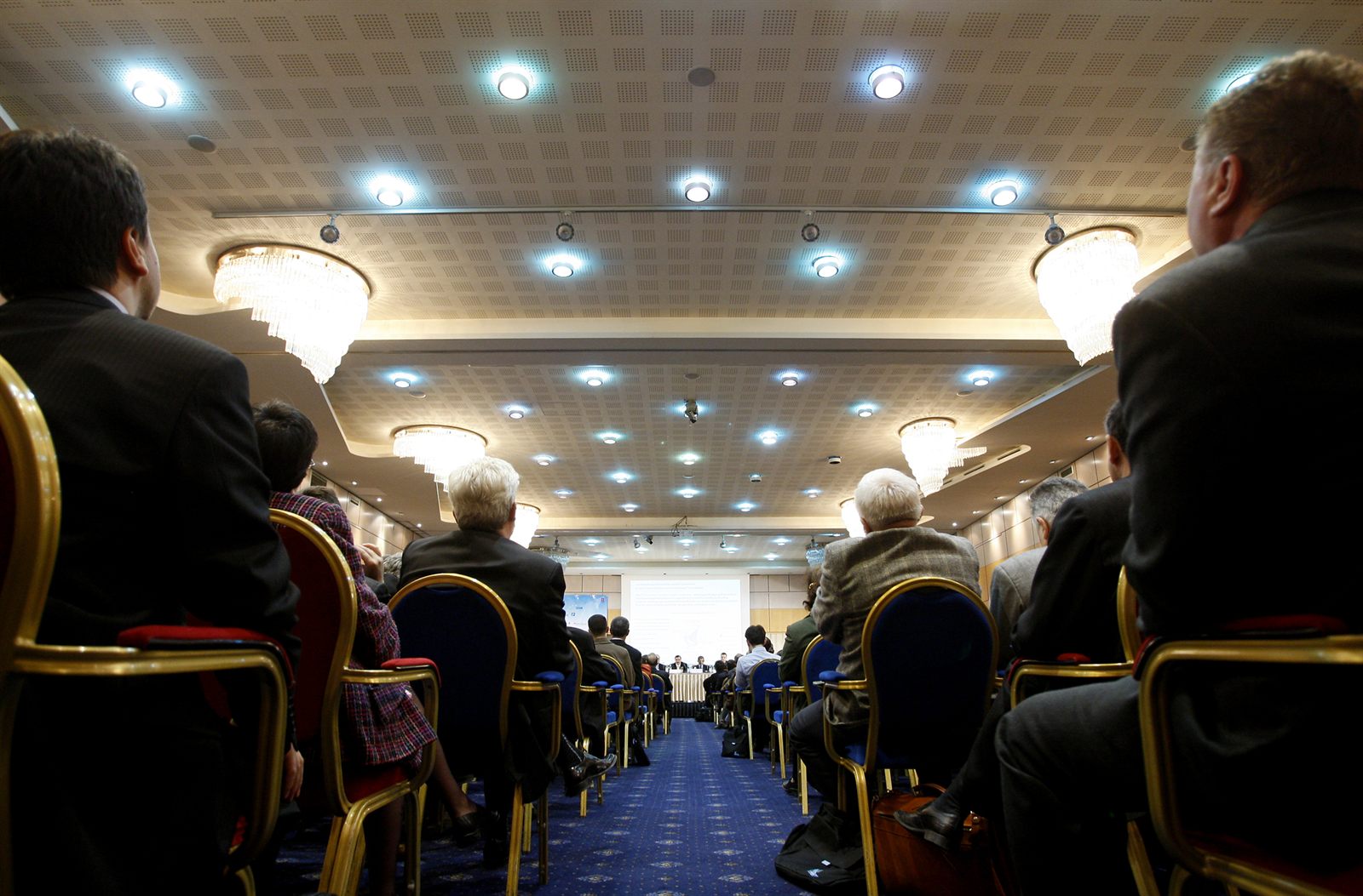 Formal conference hall with attendees seated in rows